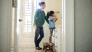 mother showing child how to brush her teeth