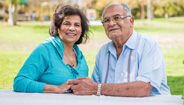 An elderly couple holding hands