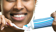 Smiling woman with toothbrush and toothpaste