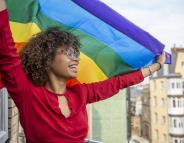 women smiling holding pride flag women smiling holding pride flag
