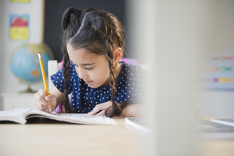 girl writing in notebook with pencil