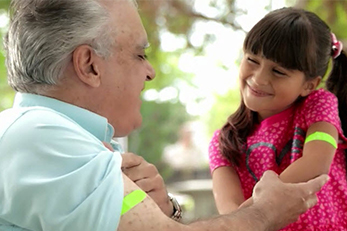 grandfather and granddaughter showing off vaccination bandaids